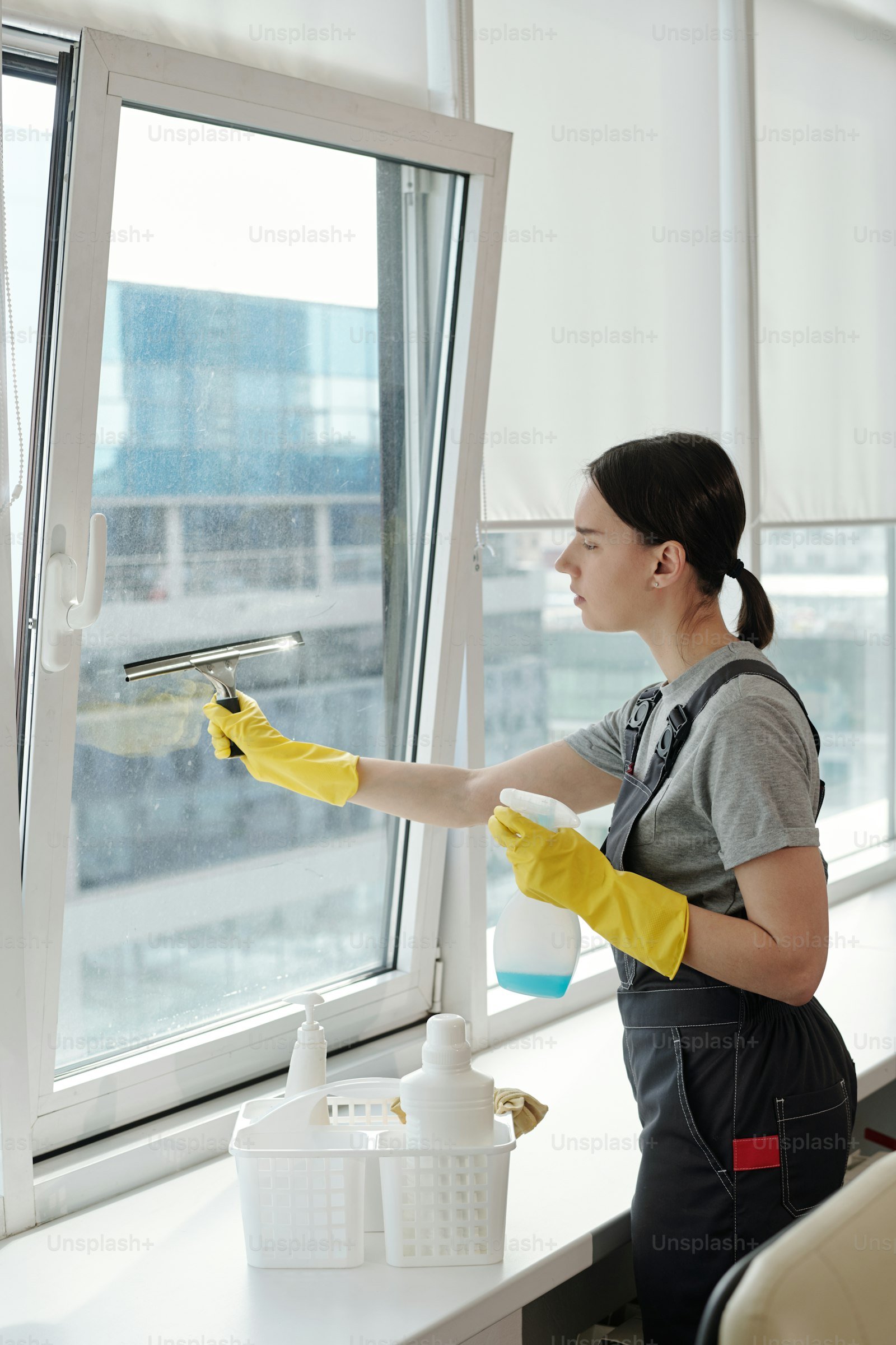 Cleaner spraying and wiping office glass wall
