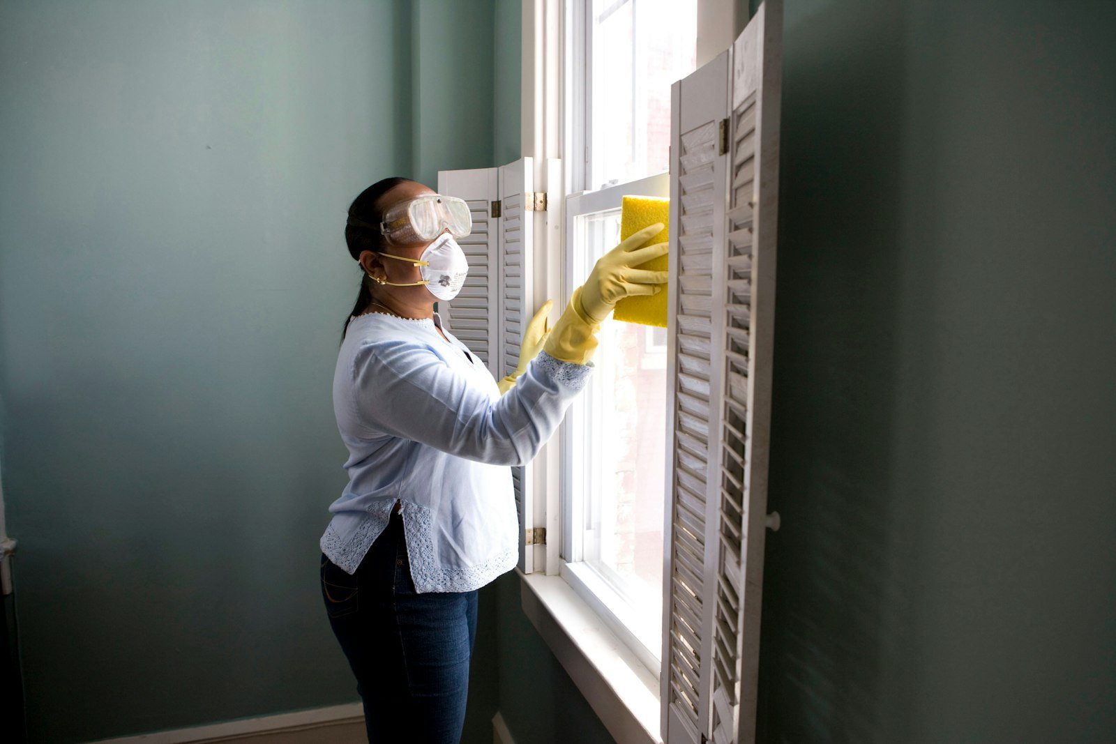 Professional cleaner wiping interior glass surface
